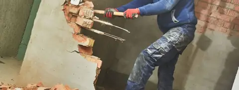 Brick wall being broken out during interior demolition