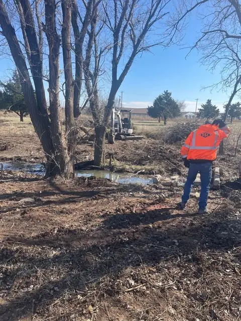 Worker in a safety vest on a clearing job